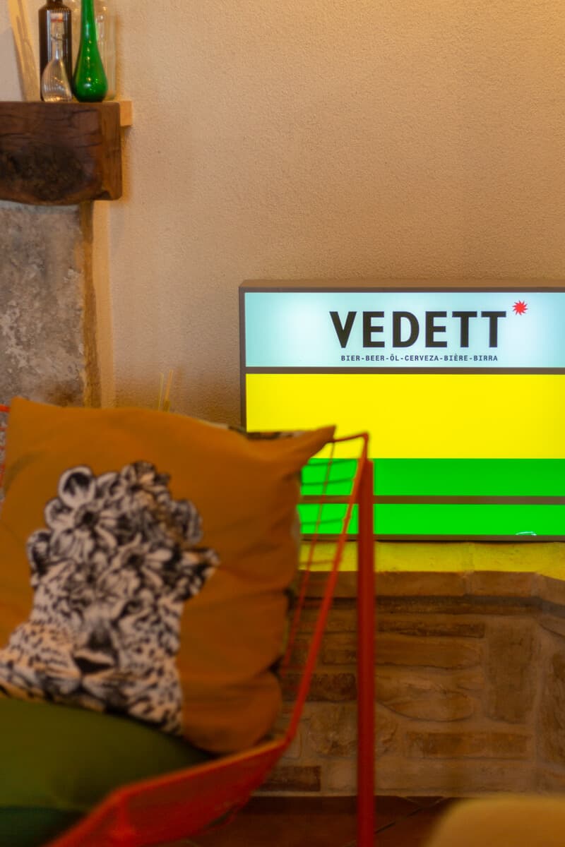 Living room corner with colorful cushions and Vedett light sign